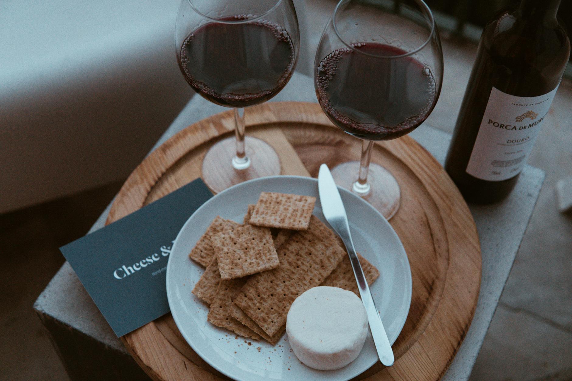 Czerwone wino i sery na rustykalnej desce w portugalskim stylu
