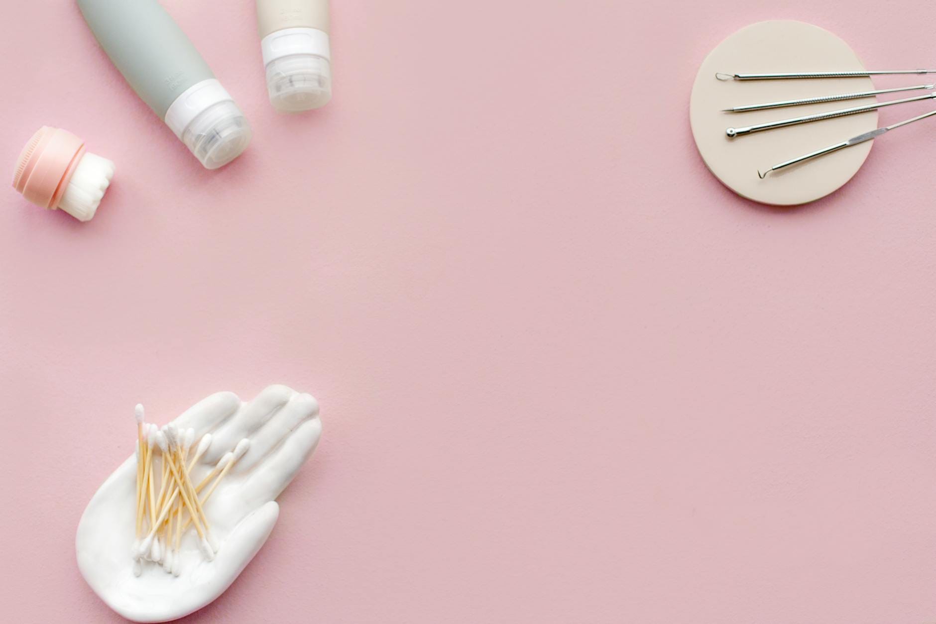 Jak łączyć retinol z kwasami, witaminą C i nawilżaczami w jednej rutynie Płaskie ułożenie kosmetyków i akcesoriów do pielęgnacji skóry na różowym tle